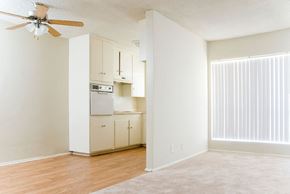 North Hollywood apartment for rent - an empty living room with a kitchen with a ceiling fan