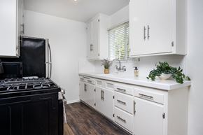 Beverly Hills apartment for rent - a kitchen with white cabinets and a black stove