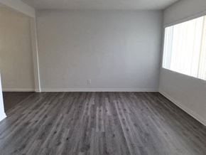 Whittier apartment for rent - an empty living room with wooden floors and a window