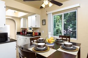 San Pedro apartment for rent - a kitchen and dining room with a table and chairs and a large window