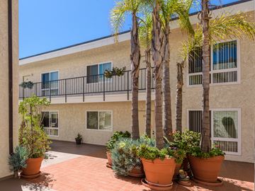 San Pedro apartment for rent - A balcony with a railing and potted plants.