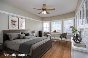Long Beach apartment for rent - A bedroom with a bed, chair, and a ceiling fan.