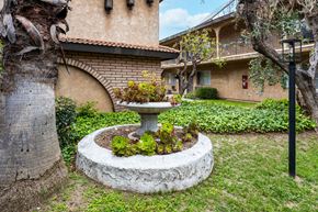 Temple City apartment for rent - a fountain sits in the middle of a grassy area in front of a building