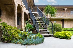 Temple City apartment for rent - a staircase with a black railing and green plants in front of it