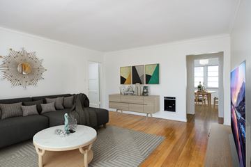Los Angeles apartment for rent - a living room with a black couch and a white table