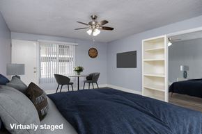 Long Beach apartment for rent - A bedroom with a bed, a table with chairs, a clock, and a shelf.