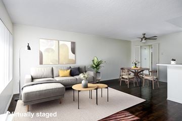 Canoga Park apartment for rent - A living room with a grey couch, a coffee table, and a dining table set up.