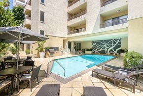 Los Angeles apartment for rent - A large outdoor pool area with a table and chairs.