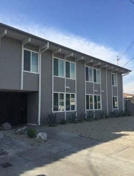 Whittier apartment for rent - a large gray building with a driveway in front of it