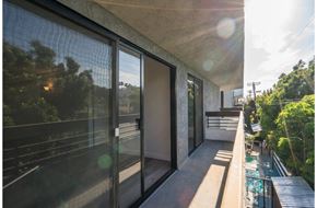 Los Angeles apartment for rent - a balcony with glass doors and a view of trees and a pool
