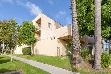 Inglewood apartment for rent - a beige apartment building with trees and a sidewalk