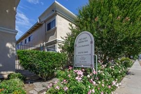 Chatsworth apartment for rent - a building with a sign and flowers in front of it