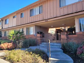Whittier apartment for rent - the front entrance of a building with stairs and a metal gate