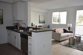 Reseda apartment for rent - A modern kitchen with white cabinets and a black countertop.