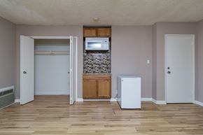 Los Angeles apartment for rent - A room with a white fridge and a stone wall.