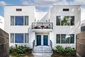 Los Angeles apartment for rent - the front facade of a white house with blue doors and a balcony