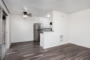 Gardena apartment for rent - an empty living room with a kitchen and a ceiling fan