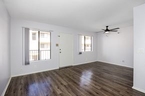 Hawthorne apartment for rent - an empty living room with white walls and a ceiling fan