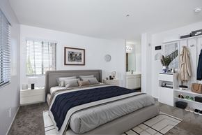 Torrance apartment for rent - A bedroom with a large bed and a clothing rack.