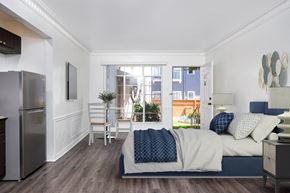 Los Angeles apartment for rent - a bedroom with a bed and a refrigerator and a window