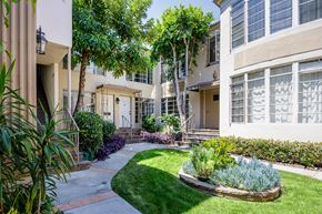 Los Angeles apartment for rent - the front yard of an apartment building with green grass and trees