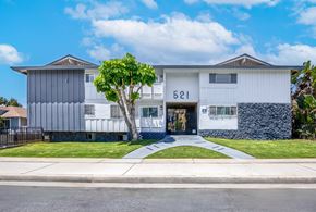Inglewood apartment for rent - A modern two-story house with a white and grey exterior and a tree in front.