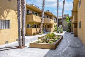 Inglewood apartment for rent - A row of apartment buildings with a planter in the foreground.