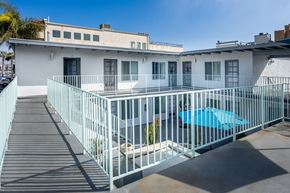 Long Beach apartment for rent - A white building with a blue pool in front.