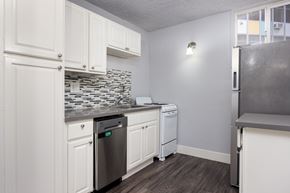 Long Beach apartment for rent - A kitchen with white cabinets and a black dishwasher.