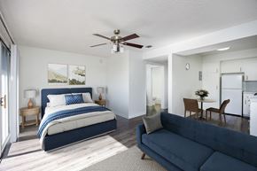 Van Nuys apartment for rent - A bedroom with a large bed and a living room with a couch.