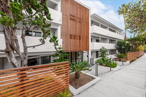 Los Angeles apartment for rent - A modern building with a wooden fence and plants in front.
