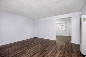 Hawthorne apartment for rent - Empty room with wooden floor and white walls.