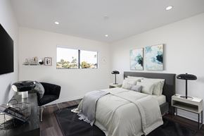 Redondo Beach apartment for rent - A modern bedroom with a large bed and a black chair.