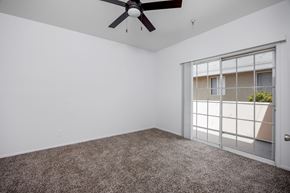 Hawthorne apartment for rent - A room with a ceiling fan and carpeted floor.