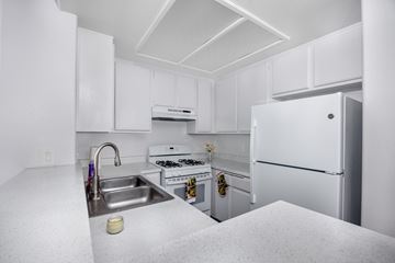 Hawthorne apartment for rent - A white kitchen with a sink, stove, and refrigerator.