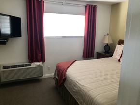 Long Beach apartment for rent - a bedroom with a bed and a window with red curtains