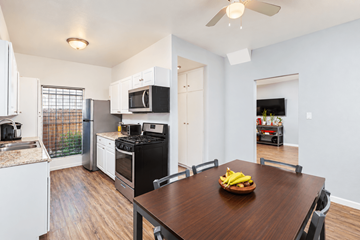 Long Beach apartment for rent - A kitchen with a table and chairs and a bowl of bananas on it.