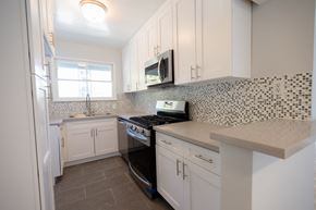 West Hollywood apartment for rent - a kitchen with white cabinets and a stove and a microwave