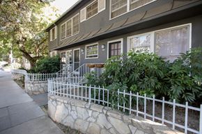 West Hollywood apartment for rent - the exterior of a gray house with a white fence