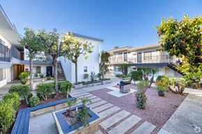 Sherman Oaks apartment for rent - A courtyard with a small garden and a white building in the background.