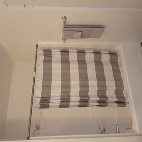 Whittier apartment for rent - A shower curtain with a striped pattern hangs in a white shower.