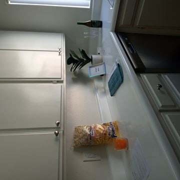 Whittier apartment for rent - A kitchen counter with a bag of popcorn and a plant on it.
