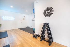 Sherman Oaks apartment for rent - A gym with a wooden floor, a wall-mounted sign, and a blue exercise ball.