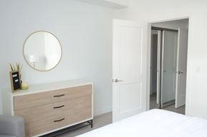 Reseda apartment for rent - A white bedroom with a round mirror and a white dresser.