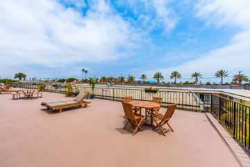 San Pedro apartment for rent - A patio with a table and chairs overlooking a pool.