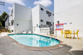 West Hollywood apartment for rent - the pool of a building with yellow chairs and a swimming pool