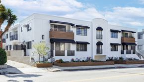 West Hollywood apartment for rent - the exterior of a white building with black and white balconies and a street