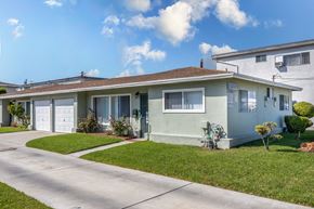 Gardena apartment for rent - a blue and white house with a driveway and lawn