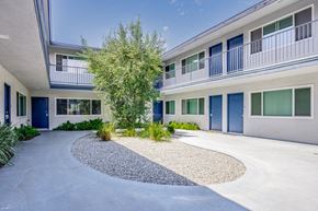 Long Beach apartment for rent - the entrance to a building with blue doors and a tree in the center