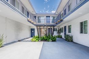 Long Beach apartment for rent - the courtyard of a white building with a blue door